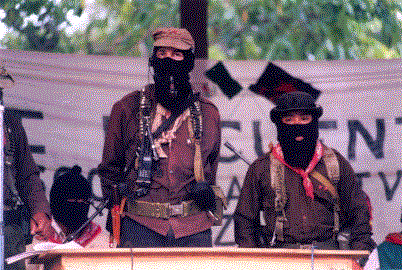 Subcomandante Marcos and Comandante Tacho in La Realidad, Chiapas, 1999, by Cesar Bojorquez, licensed under CC BY 2.0. Depicts Subcomandante Marcos, an Ejército Zapatista de la Liberación Nacional revolutionary, alongside Comandante Tacho.