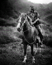 Subcomandante Marcos, the spokesman of the Ejército Zapatista de Liberación Nacional, striking a pose, smoking a pipe atop a horse in Chiapas, Mexico, by Jose Villa, licensed under CC BY-SA 3.0.